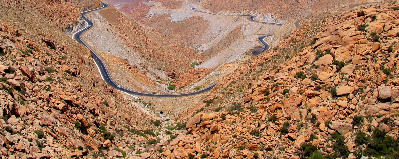 La carretera de La Rumorosa serpenteando en curvas cerradas por el fondo de un cañón de peñascos de granito rojizo, en la sierra de Baja California