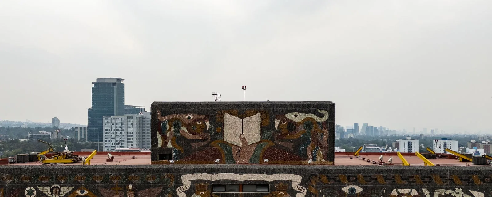 El remate de la Biblioteca Central de la UNAM con el mosaico de piedra de Juan O'Gorman, y la ciudad extendiéndose detrás