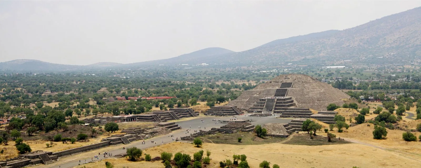 La Calzada de los Muertos de Teotihuacán vista desde lo alto, con la Pirámide de la Luna al fondo y el valle abriéndose hacia los cerros