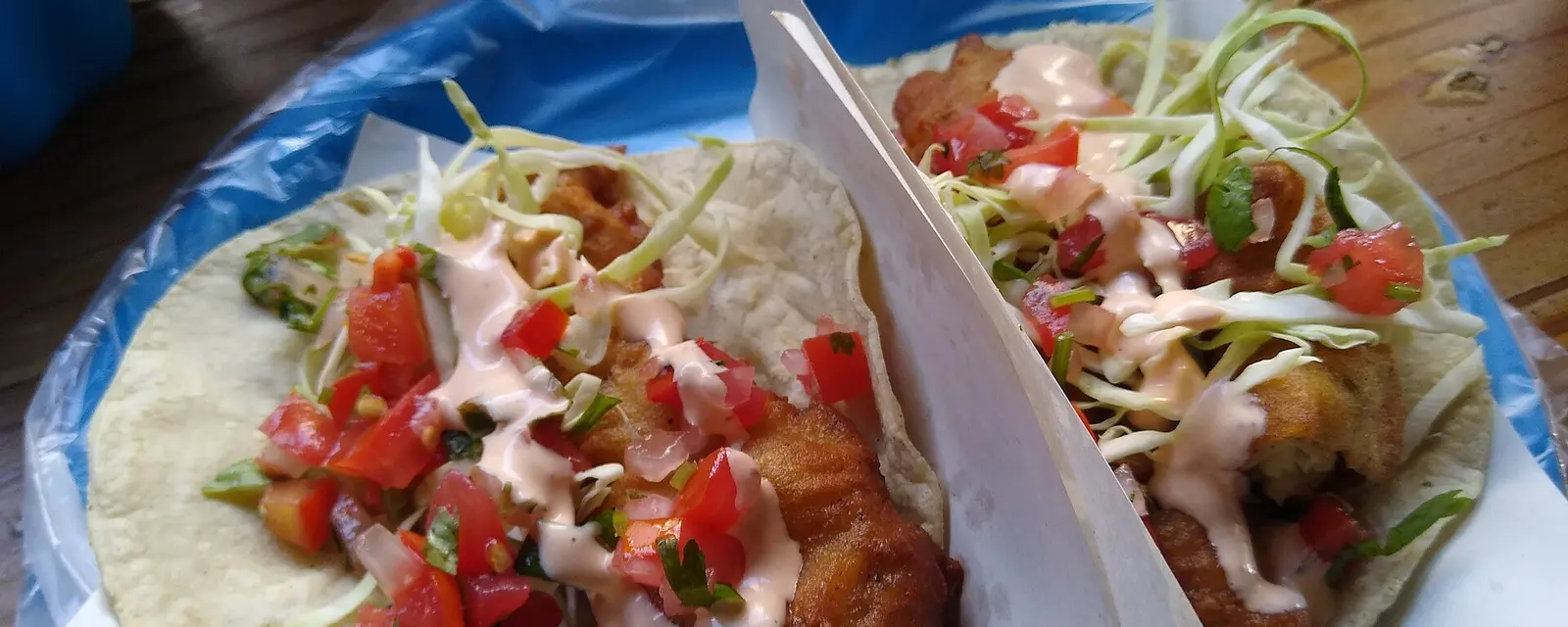 Tacos de pescado estilo Ensenada con repollo, crema y salsa sobre tortillas de maíz