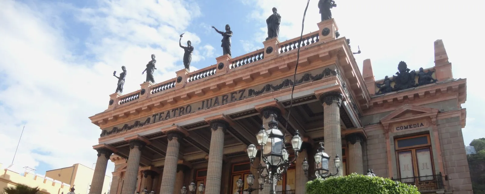 La fachada del Teatro Juárez de Guanajuato vista desde abajo: su columnata de cantera coronada por las ocho musas de bronce