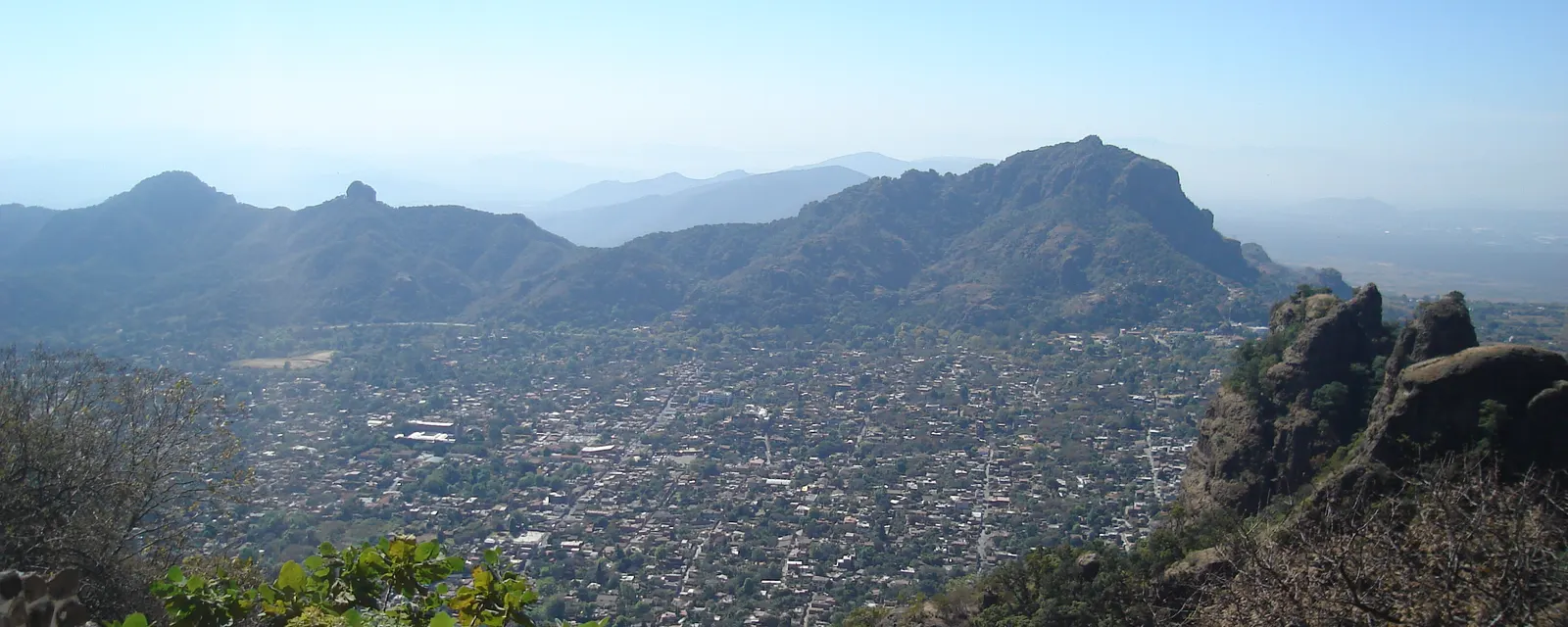 El pueblo de Tepoztlán en el fondo del valle, visto desde la altura del Tepozteco y rodeado por los farallones de roca de la sierra